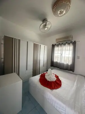 a bedroom with a bed with a red and white flower on it at P&I Group Home 4 Karon beach in Karon Beach