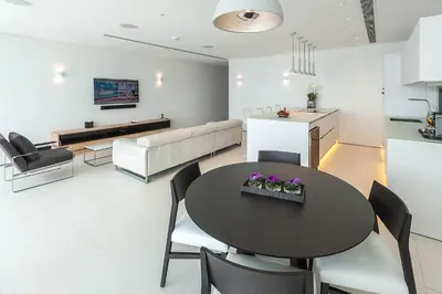 a kitchen and living room with a table and chairs at Kata Rocks in Kata Beach