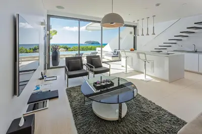 a living room with a glass table and chairs at Kata Rocks in Kata Beach