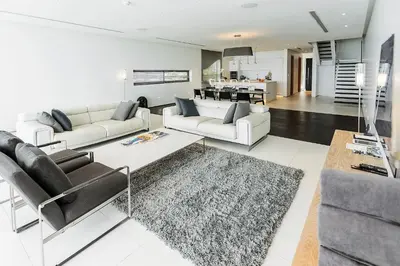 a living room with two white couches and a kitchen at Kata Rocks in Kata Beach