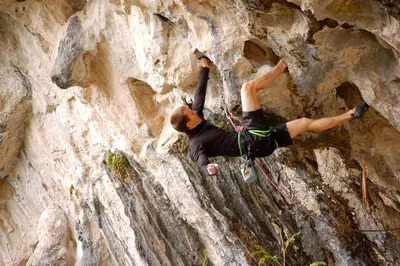a woman is climbing on a rock wall at Songbird Suites in Ban Khlong Haeng