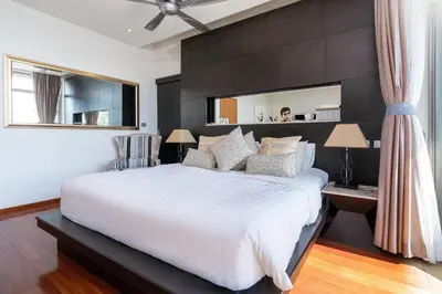 a bedroom with a large white bed and a mirror at Sea view Villa on Rawai beach in Ban Saiyuan (1)