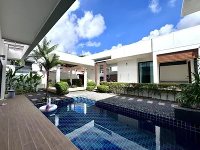 a swimming pool in front of a house at Funtime pool villa in Kata Beach
