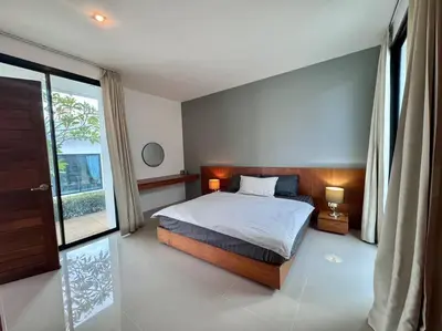 a bedroom with a bed and a large window at Funtime pool villa in Kata Beach