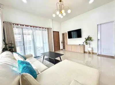 a living room with a white couch and a table at Mali Villa in Ban Suan