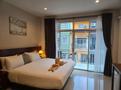 a teddy bear sitting on a bed in a bedroom at NJoy Boutique Guesthouse in Patong Beach