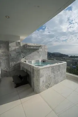a large stone tub in a room with a window at Kata Beach TheView luxurious Condonomium in Kata Beach