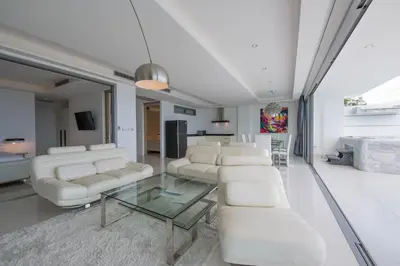 a living room with white furniture and a glass table at Kata Beach TheView luxurious Condonomium in Kata Beach