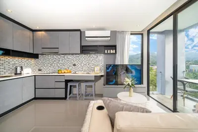 a kitchen and living room with a couch at Citygate Kamala Resort in Kamala Beach