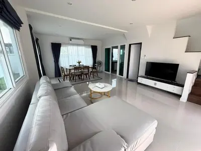 a living room with a white couch and a table at Cozy House by Cody One in Thalang