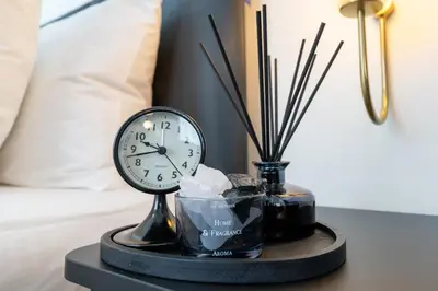 a clock sitting on a table next to a bed at House 158 Patong Pool Villa 4BR Near Beach in Patong Beach