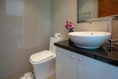 a bathroom with a white sink and a toilet at Sea View & Tropical Bliss - 2BR Villa Natural Touch A4 at Kamala Hill in Kamala Beach