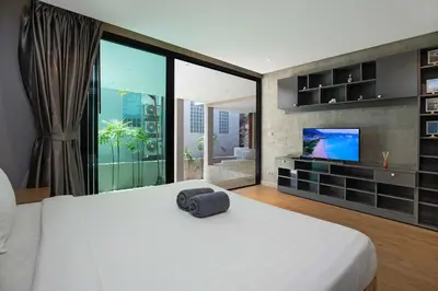 a bedroom with a large white bed and a television at Sea View & Tropical Bliss - 2BR Villa Natural Touch A4 at Kamala Hill in Kamala Beach