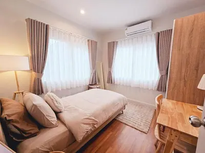 a bedroom with a bed and a desk and windows at Little Cottage - 3BR House for family vacation By Little Latte House in Ban Pa Khlok