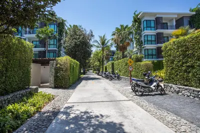 a row of motorcycles parked on a sidewalk in front of a building at Tropical Pool View 1BR Apartment TTL F303 in Rawai Beach Residence in Rawai Beach