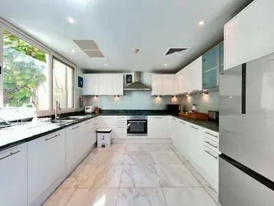 a kitchen with white cabinets and a large window at 30 - Panoramic View Villa in Thalang in Thalang