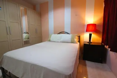 a bedroom with a white bed and a red lamp at 2 bedroom Semi-Detached Holiday Home with Pool near Kamala Beach in Kamala Beach