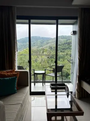 a living room with a couch and a glass table at Mida 1 in Phuket Town