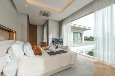 a large white bed in a room with a large window at Nature's Rest Private Pool Villa Rawai in Phuket Town