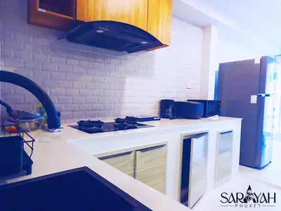 a kitchen with a stove and a counter top at Sarayah Phuket Pool Villa in Phuket Town