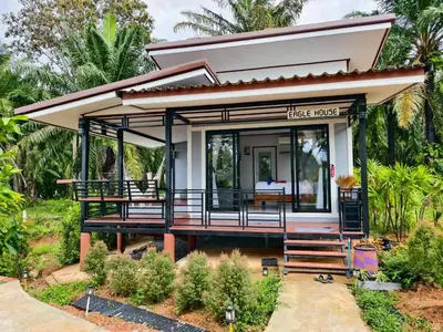 a small house with a large deck in a garden at Relax sunsmile Kohyaonoi in Ko Yao Noi