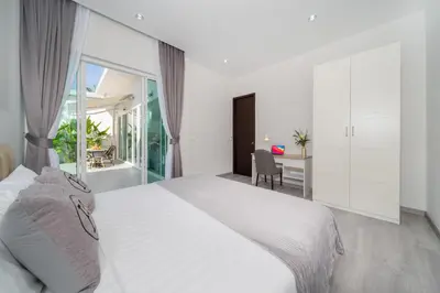 a white bedroom with a large bed and a desk at Brand New Villa in Ravai for a wonderful holiday 3 - bedroom in Ban Saiyuan (1)
