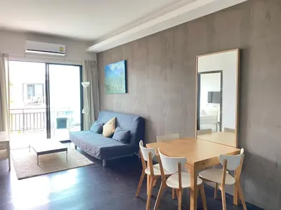 a living room with a blue couch and a table at Pond View apartment Title Rawai by Clavis in Rawai Beach