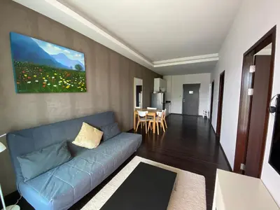 a living room with a blue couch and a table at Pond View apartment Title Rawai by Clavis in Rawai Beach