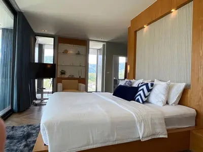 a large bedroom with a large white bed with pillows at Seaview 2 BR Spacious Modern Duplex near Kamala beach in Kamala Beach