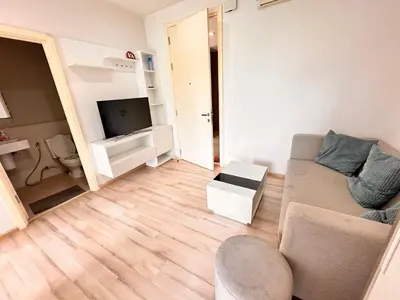 a living room with a couch and a television at the base updown\u4e00\u5367 in Phuket Town