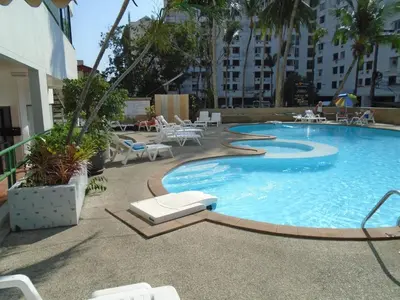 a large swimming pool with chairs and tables in a building at Condopatong in Patong Beach