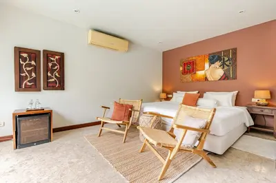 a bedroom with a bed and a table and chairs at Luxury 4BR Villa with Pool & Ocean Views on Patong in Patong Beach