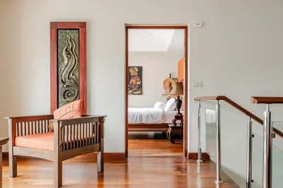 a room with a mirror and a chair and a bed at Luxury 4BR Villa with Pool & Ocean Views on Patong in Patong Beach