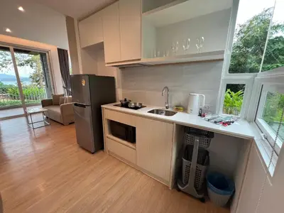 a kitchen with a refrigerator and a sink in it at Beachfront Bliss at Naiyang Phuket by ALPHATEL in Phuket