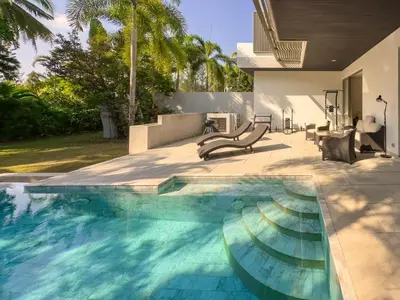 a swimming pool in the backyard of a house at Charming 3-bdr apartment with pool in Bang Tao Beach