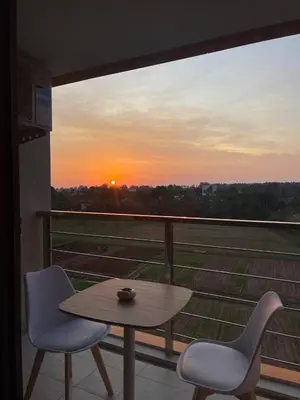 a table and two chairs on a balcony with a sunset at Sunset Room Phuket in Ban Mai Salae