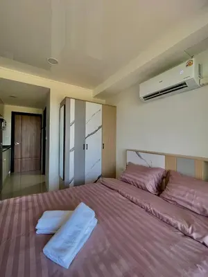 a bedroom with a large bed with purple sheets at Sunset Room Phuket in Ban Mai Salae