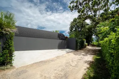 a driveway leading to a white building with a black roof at Tropical Chalet-Style 2BR Villa with Pool Pasak Paradise 2, Bangtao in Bang Tao Beach