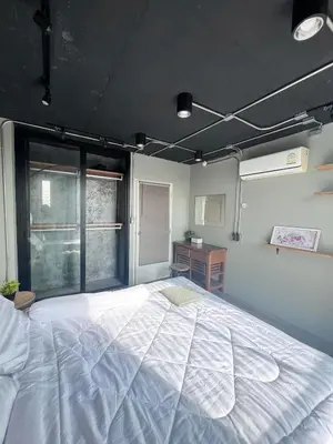a large white bed in a room with a window at Bukitta Airport Condominium by Sutanee in Ban Bo Han