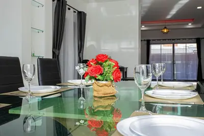a table with a vase of red roses on it at Kathu V pool villa 171 in Kathu