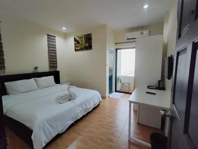 a bedroom with a bed and a desk with a television at L&K2023 Residence in Patong Beach