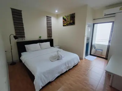 a bedroom with a large bed with a white blanket at L&K2023 Residence in Patong Beach