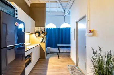 a small kitchen with a blue curtain and a table at Queen On Street Guest House in Ban Lo Long