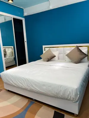 a blue bedroom with a large white bed with pillows at Queen On Street Guest House in Ban Lo Long