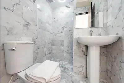 a white bathroom with a toilet and a sink at Tropical Bliss, Relax & Enjoy at 1BR Apartment MBC near Mai Khao Beach! in Mai Khao Beach