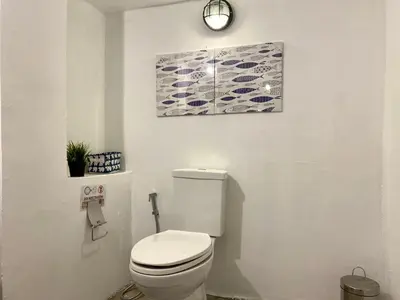 a bathroom with a toilet and a painting on the wall at Patong seaview 2bedrooms white house in Patong Beach
