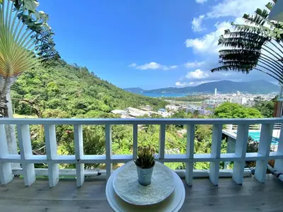 a table on a balcony with a view of a mountain at Patong seaview 2bedrooms white house in Patong Beach