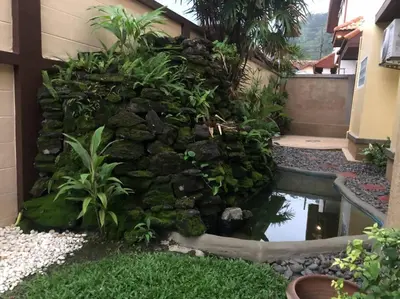 a garden with a rock wall and a pond at Luxury Pool Villa by Golf Courses & Elephant Sanctuary in Kathu
