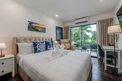 a bedroom with a large white bed with a desk at C201 Neatest Apartment The title 50m to beach and shops in Rawai Beach