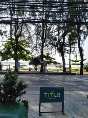 a sign in the middle of a street with trees at C201 Neatest Apartment The title 50m to beach and shops in Rawai Beach
